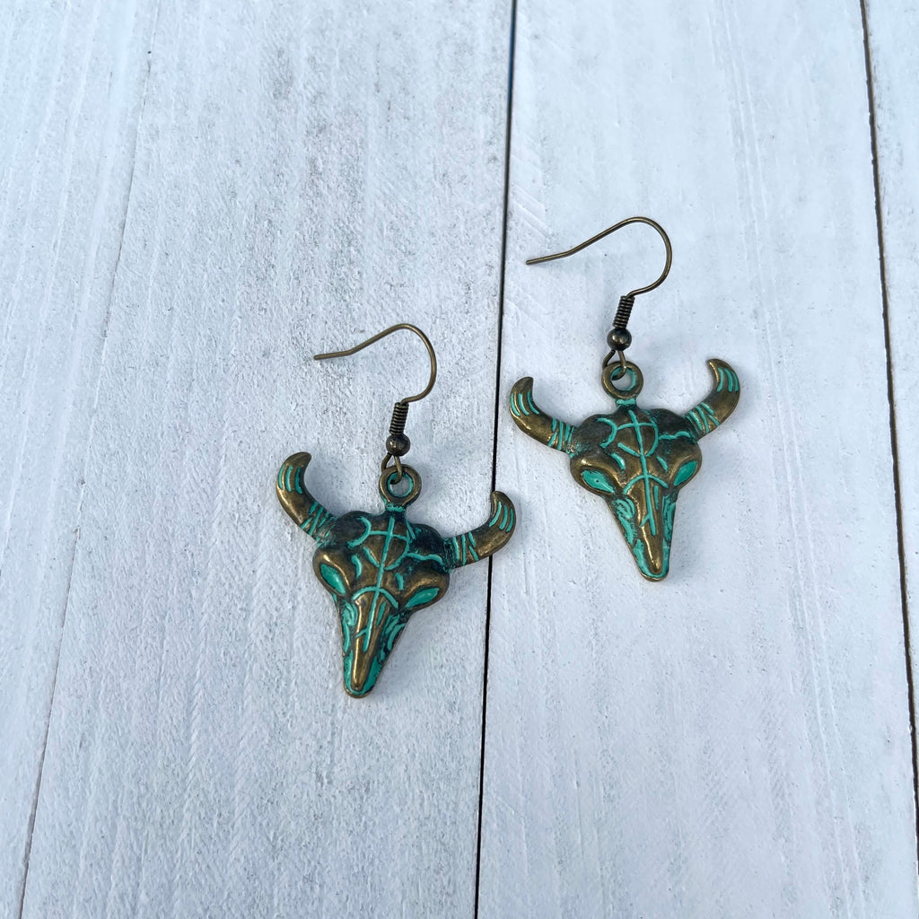 Handcrafted earrings on brass earring wires. Bronze colored pewter cow skull pendants. 