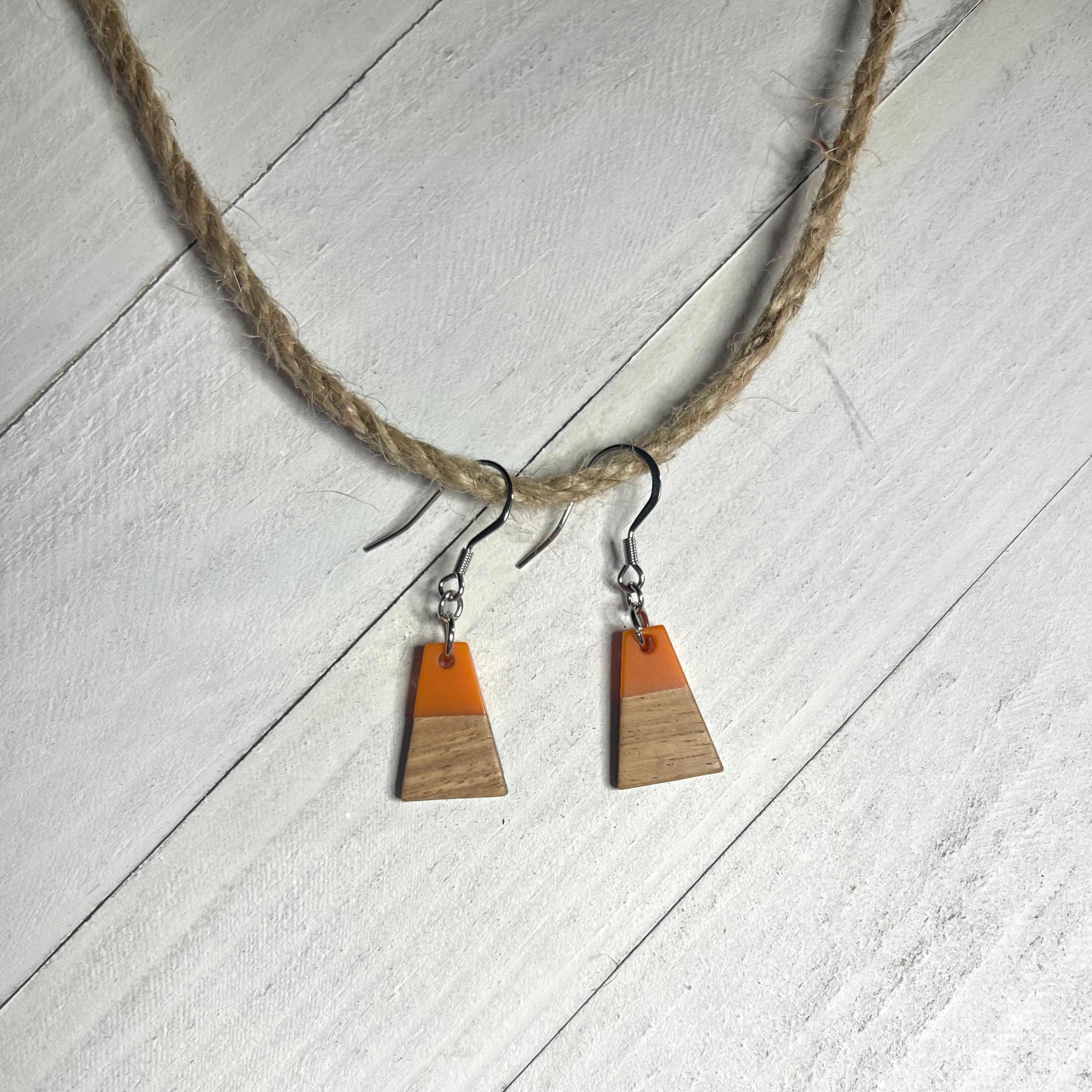 Handcrafted earrings with stainless steel earring wire and components. Orange resin and wood charms.