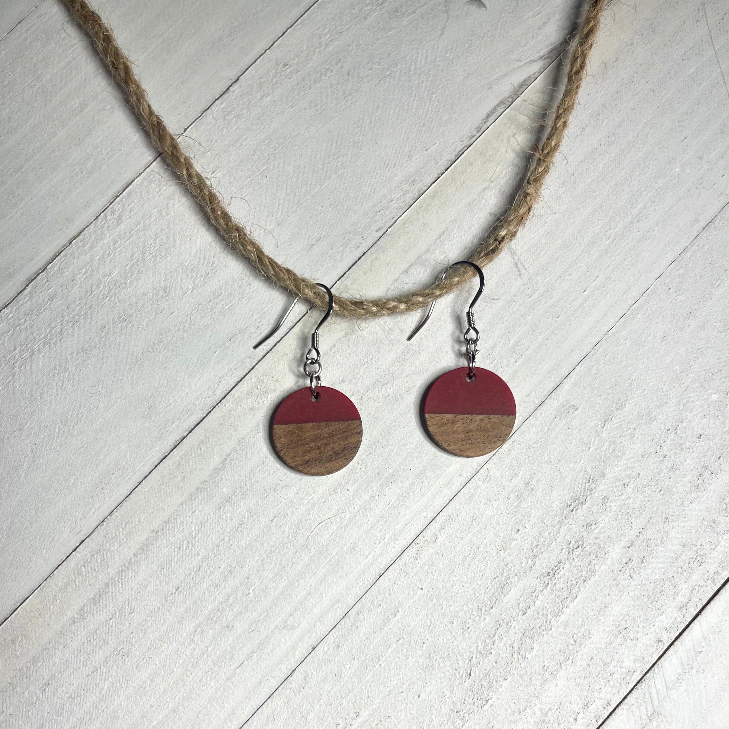 Handcrafted earrings with stainless steel earring wire and components. Red resin and wood circle charms.