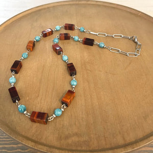 Handcrafted necklace with stainless steel chain and components. Red tiger eye, teal agate gemstones, and stainless steel beads. Measures approximately 26 1/2 inches in length.