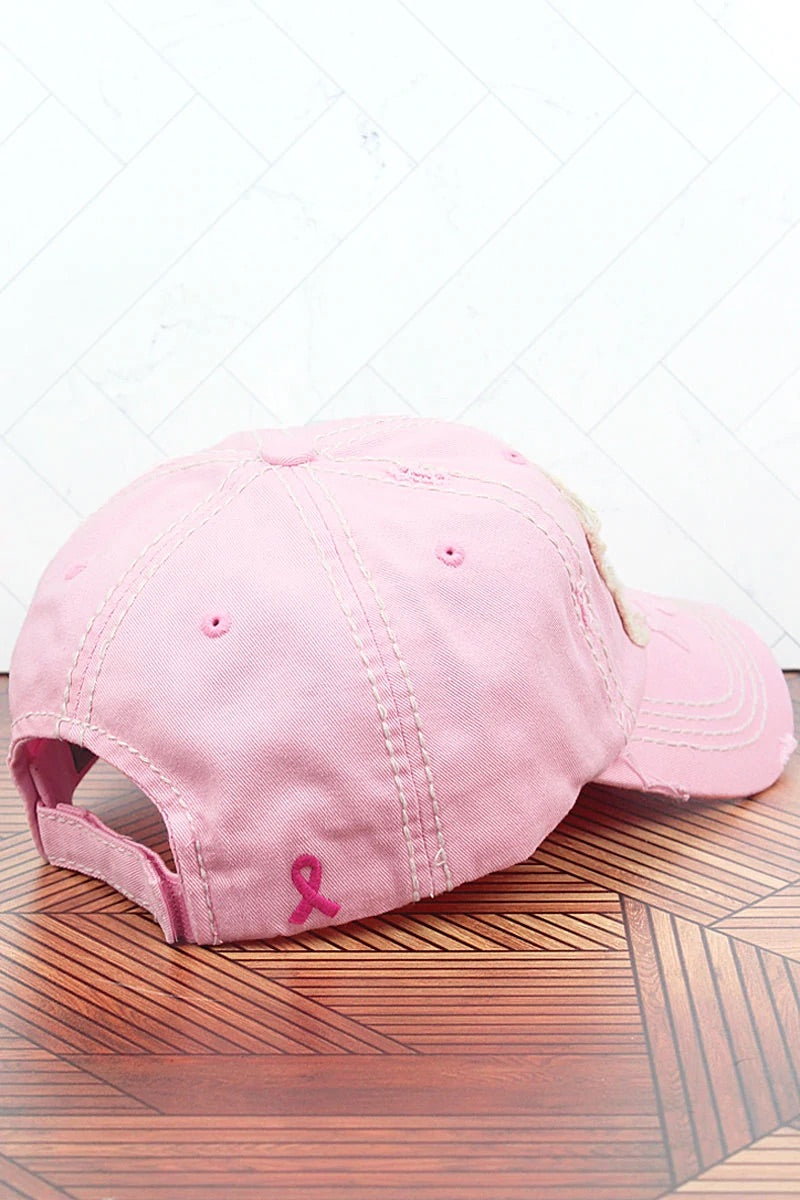 Pink distressed hat with a patch. Also has a pink ribbon stitched on the back of the hat.  100% cotton. Velcro closure.  Adjustable. One size fits most.