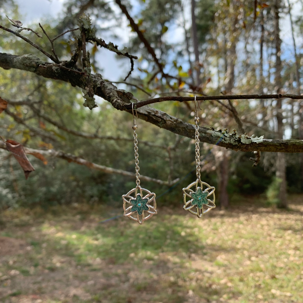 Hand crafted earrings with flower snowflake charms. Silver chain and earring wires. Nickle free.