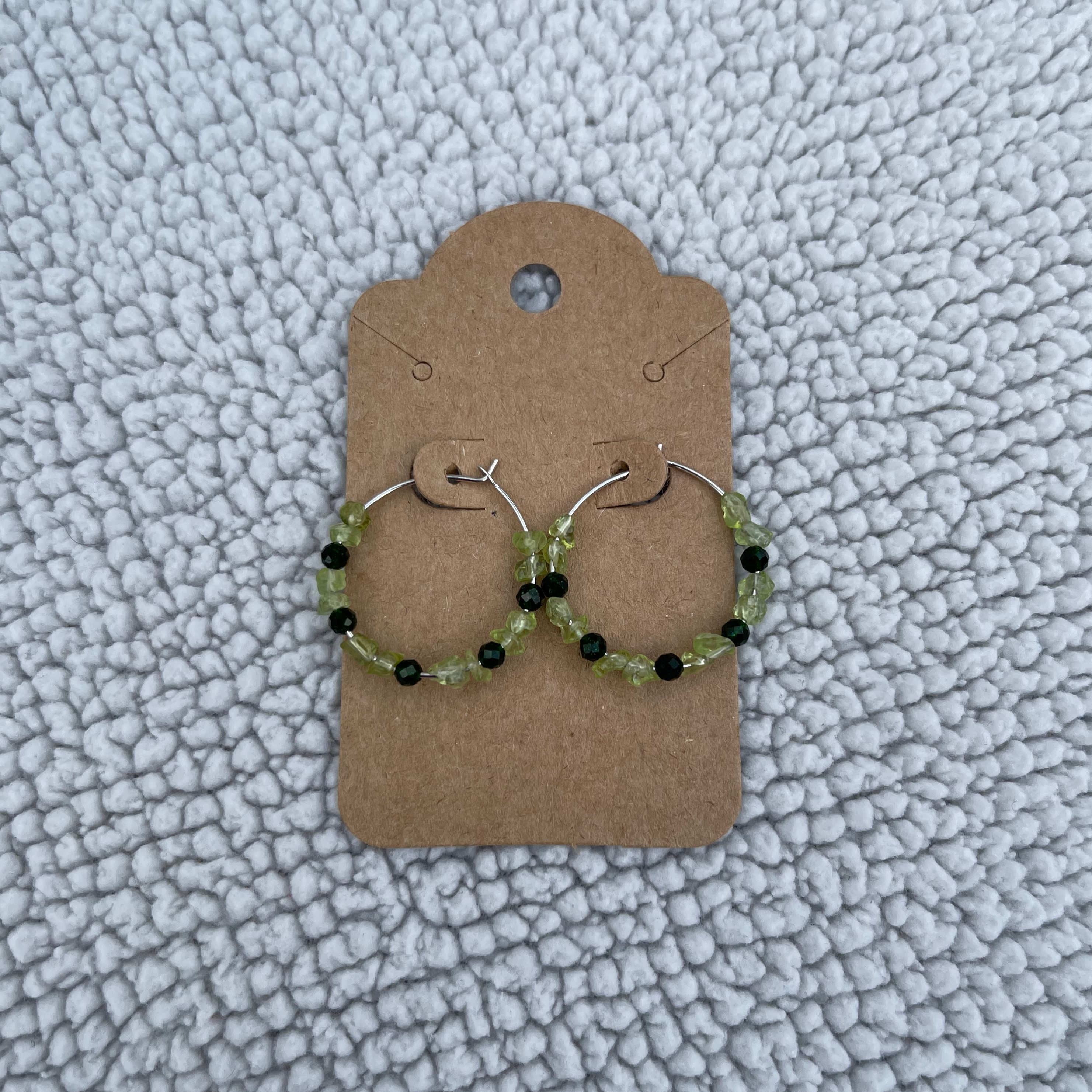 Handcrafted on 24mm silver plated hoops. Peridot chips and 3mm faceted green goldstone beads.