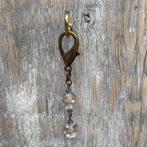 Handcrafted on purse charm on a brass lobster clasp. Glass lamp work beads with Czech glass seed beads to accent. Drop length is 3.25 inches.