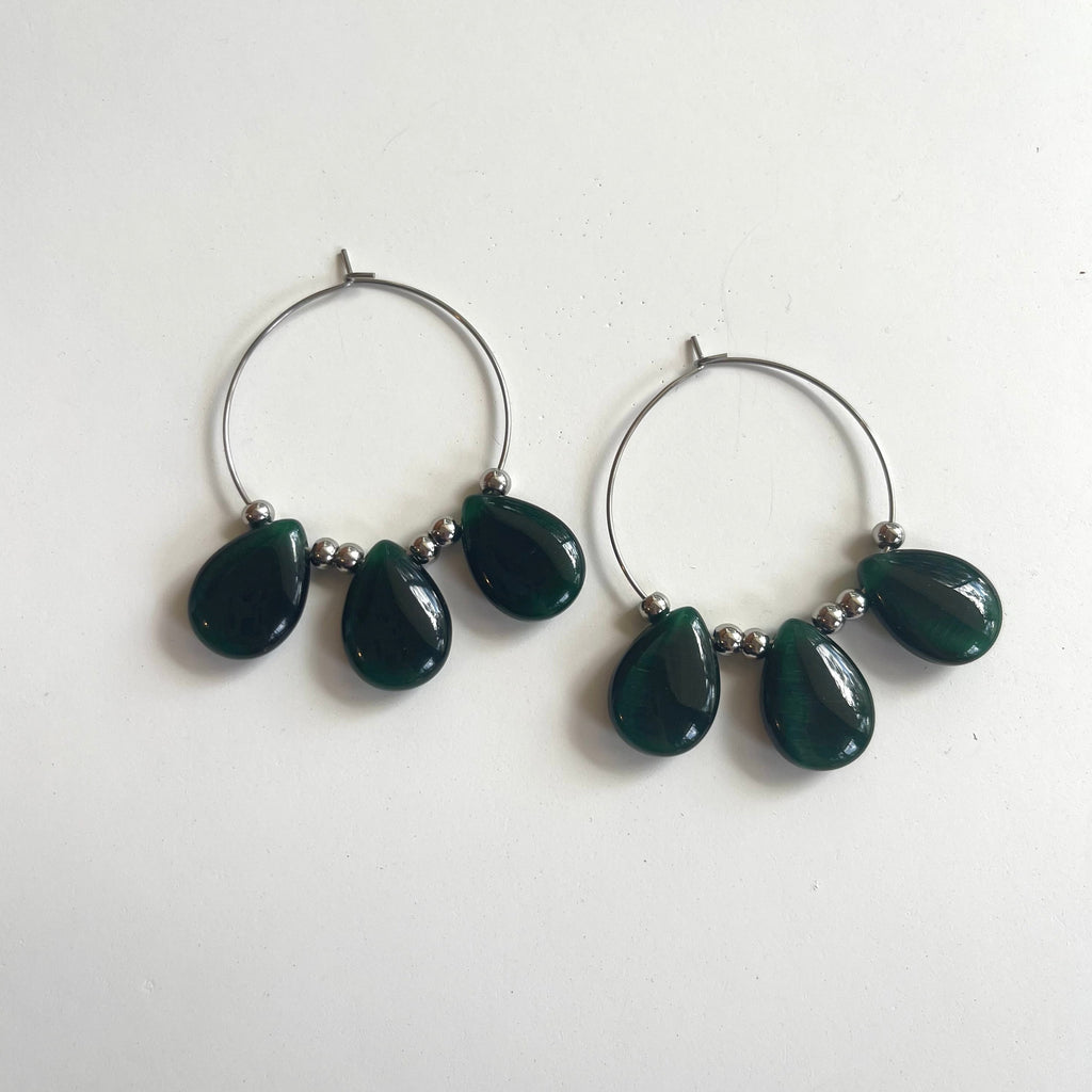 Handcrafted earrings on stainless steel 35mm hoops. Beaded with green cats eye tear drops and stainless steel round beads.