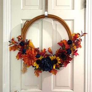 Handcrafted wreath on an upcycled lariat roping rope. Width: Approximately 21 inches. Florals and resin bull skull.