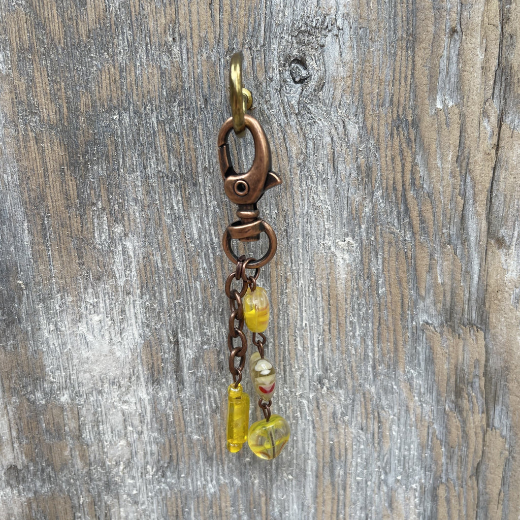 Handcrafted purse charm on an antique copper swivel lobster clasp. Antique copper chain and components. Millefiori glass heart beads in yellow and Czech glass beads. Drop length is 3.25 inches.