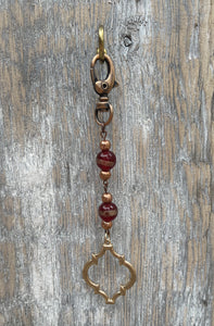 Handcrafted purse charm on an antiqure copper swivel lobster clasp. Copper and glass beads. Moroccan style metal pendant.  Drop length is 5.25 inches.