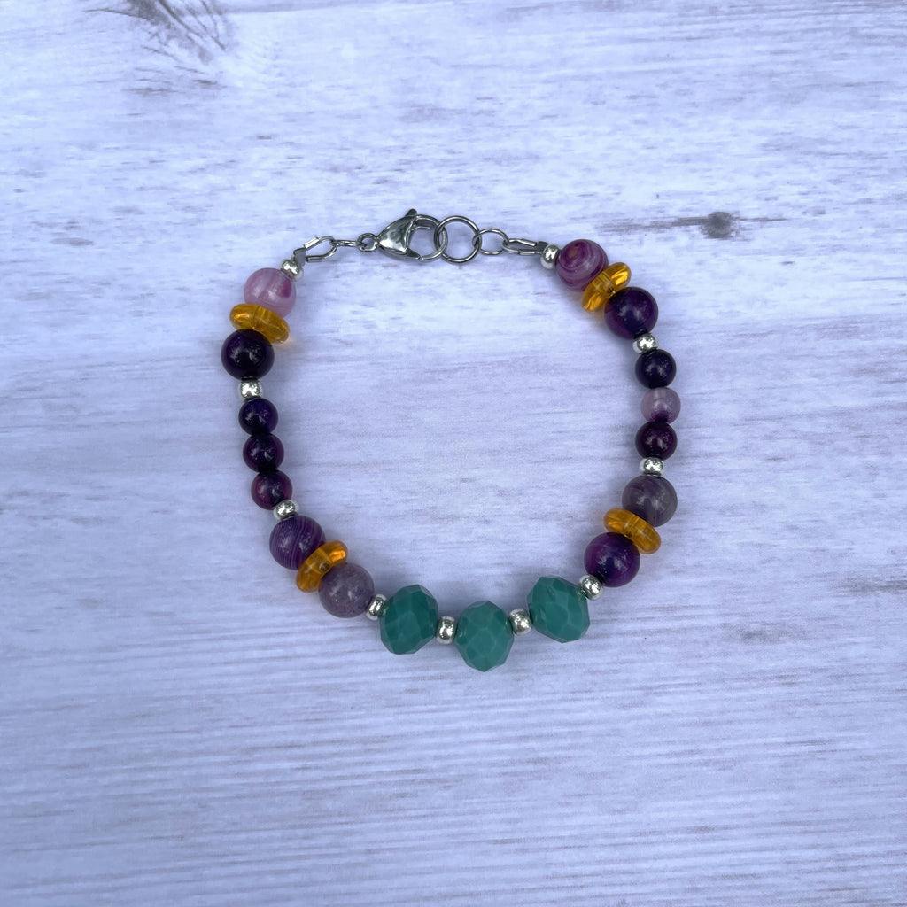 Handcrafted bracelet with all stainless steel components.  Purple striated agate, silver Czech seed beads, teal glass rondelles and orange glass spacer beads. Lobster clasp fastener. Length is 8 inches.