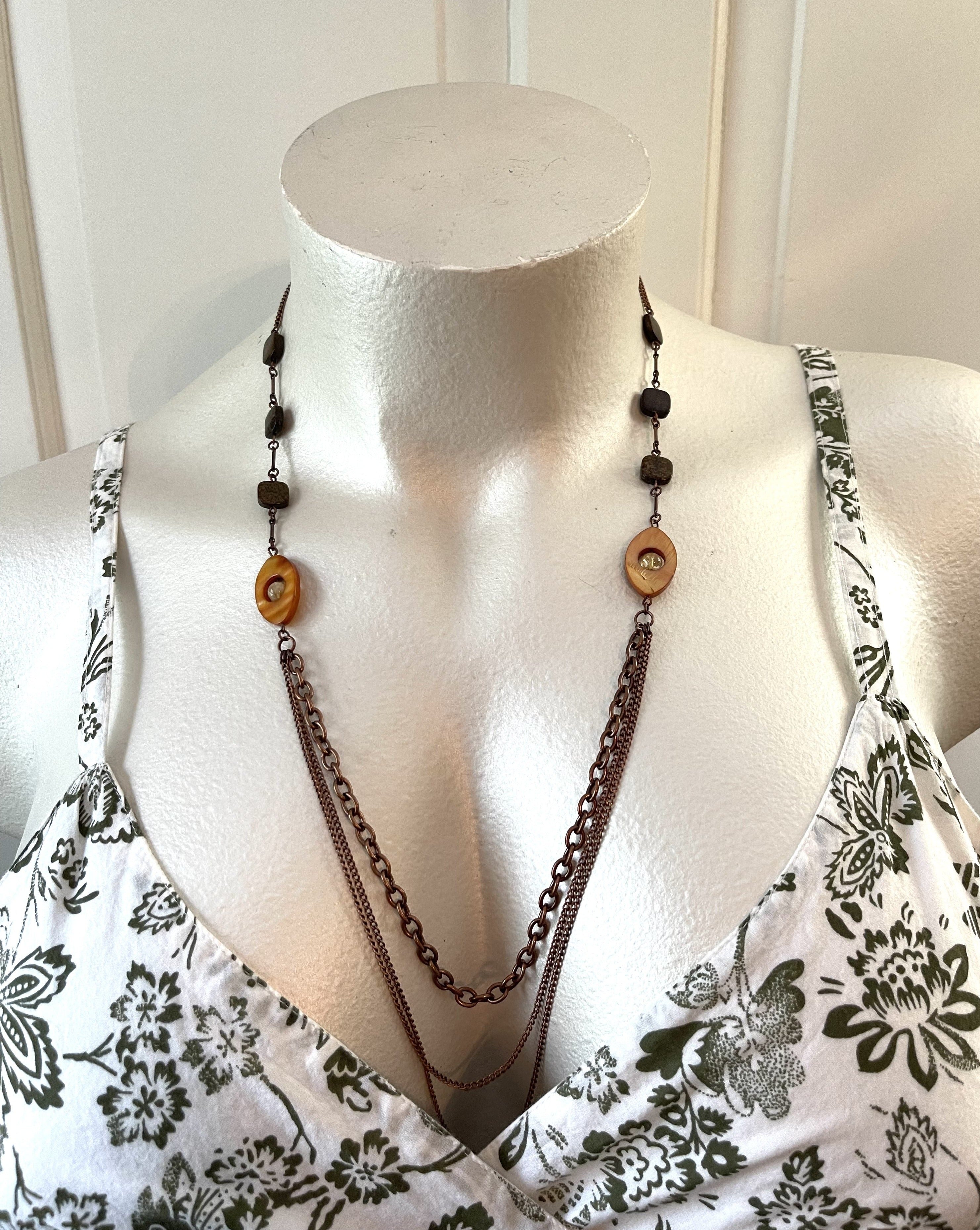 Handcrafted layered necklace on antique copper chain and components.  Dyed mother of pearl open oval flat beads, bronzite, and citrine stones. Length is approximately 30 inches. (Measured with the longest layer.)