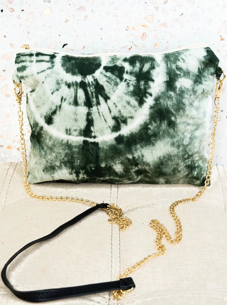 Versatile bag in trendy olive tie-dye print. 100% viscose construction. Fully lined with zipper top closure. Inside open and cell pocket. Detachable wristlet strap. Single Detachable Faux Leather and Chain Strap with 27.5" Drop. 8.5" Tall x 10.5" Wide.