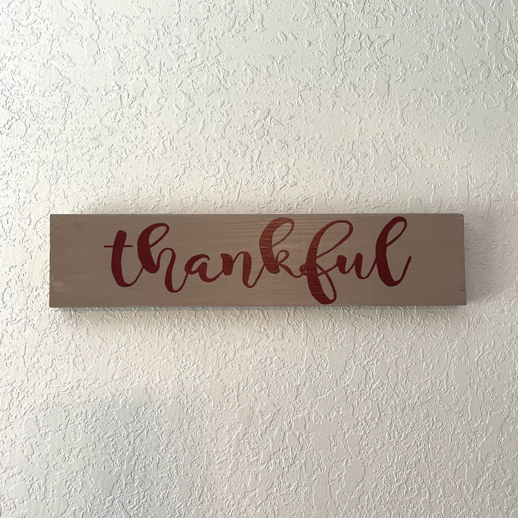 Sign is hand painted light brown and burgundy. Sign measures 15 1/2 x 3 3/8 inches. Sign can be hung or used as a leaner.