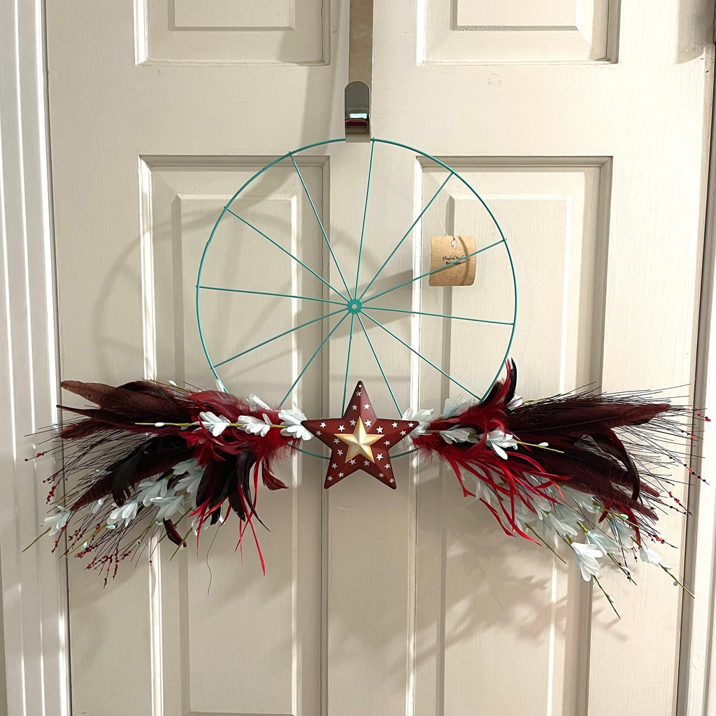 Handcrafted wreath on 14 inch metal bicycle wheel frame. Feathers and florals with a metal star.