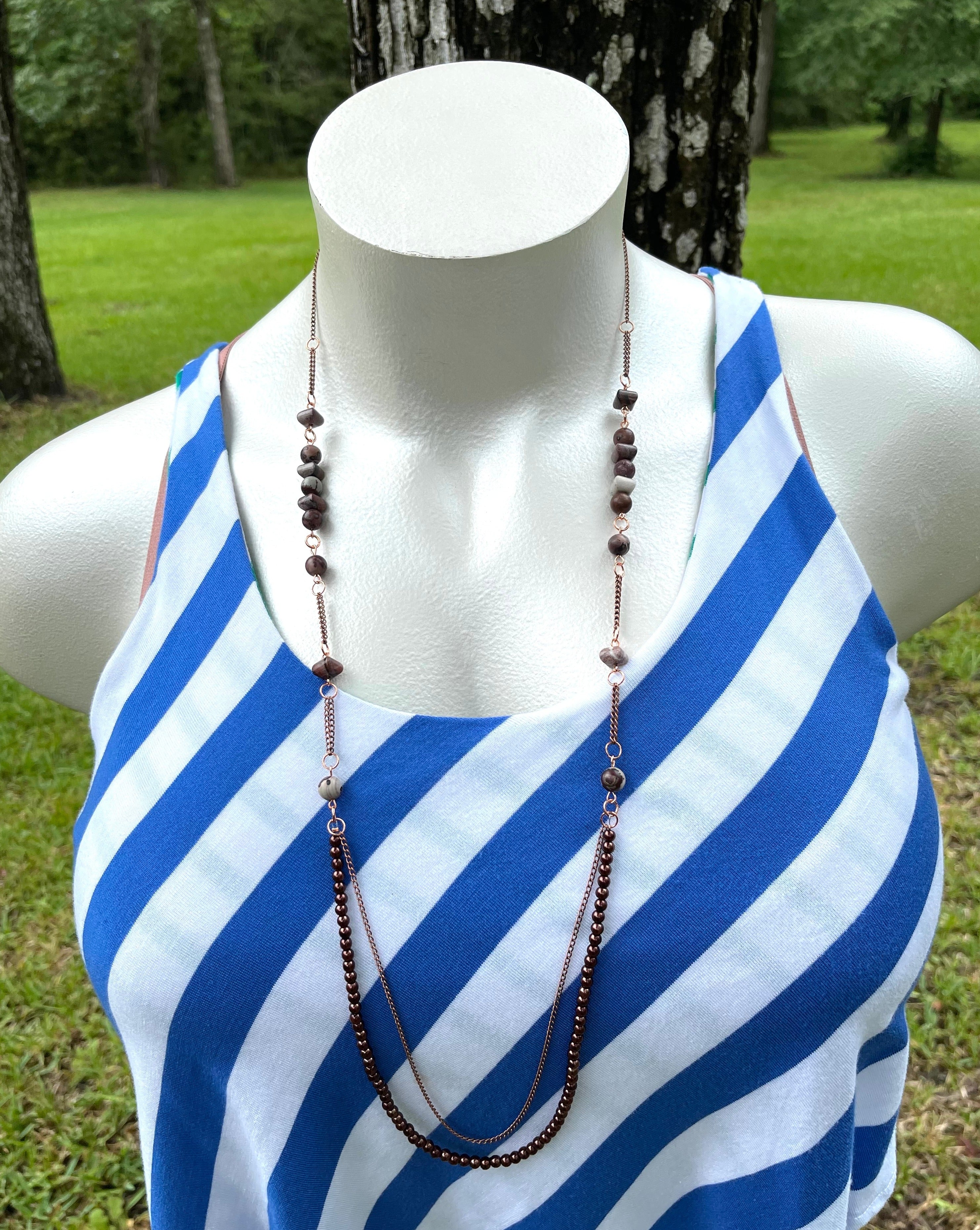 Handcrafted with antique copper chain and copper findings. Czech glass pearl coated round beads, paint brush jasper, and sun rock jasper stones. Necklace length is approximately 38 inches long. 