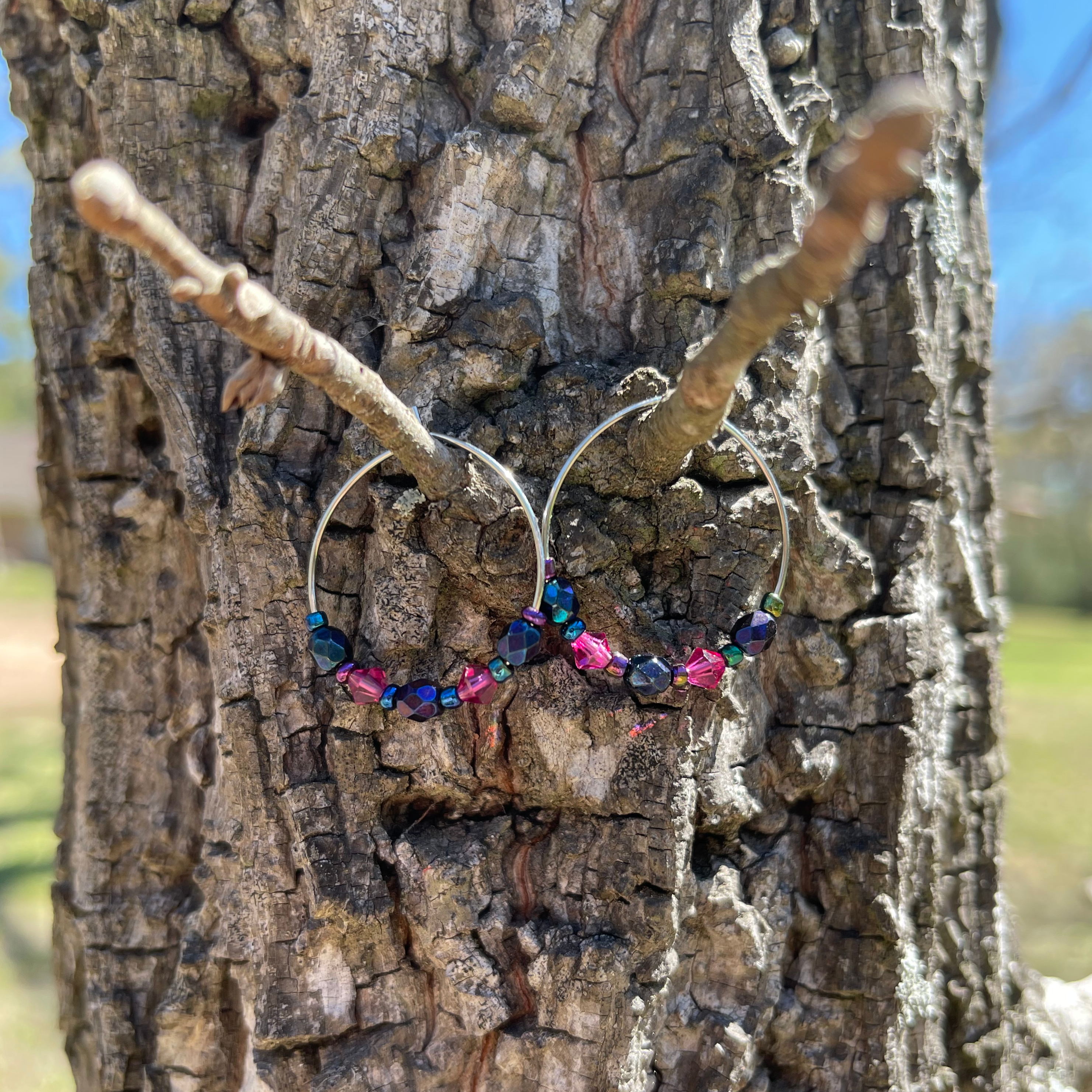 Handcrafted on 24mm sterling silver plated hoops. Blue iris faceted glass beads, glass bicone beads, and czech glass seed beads.