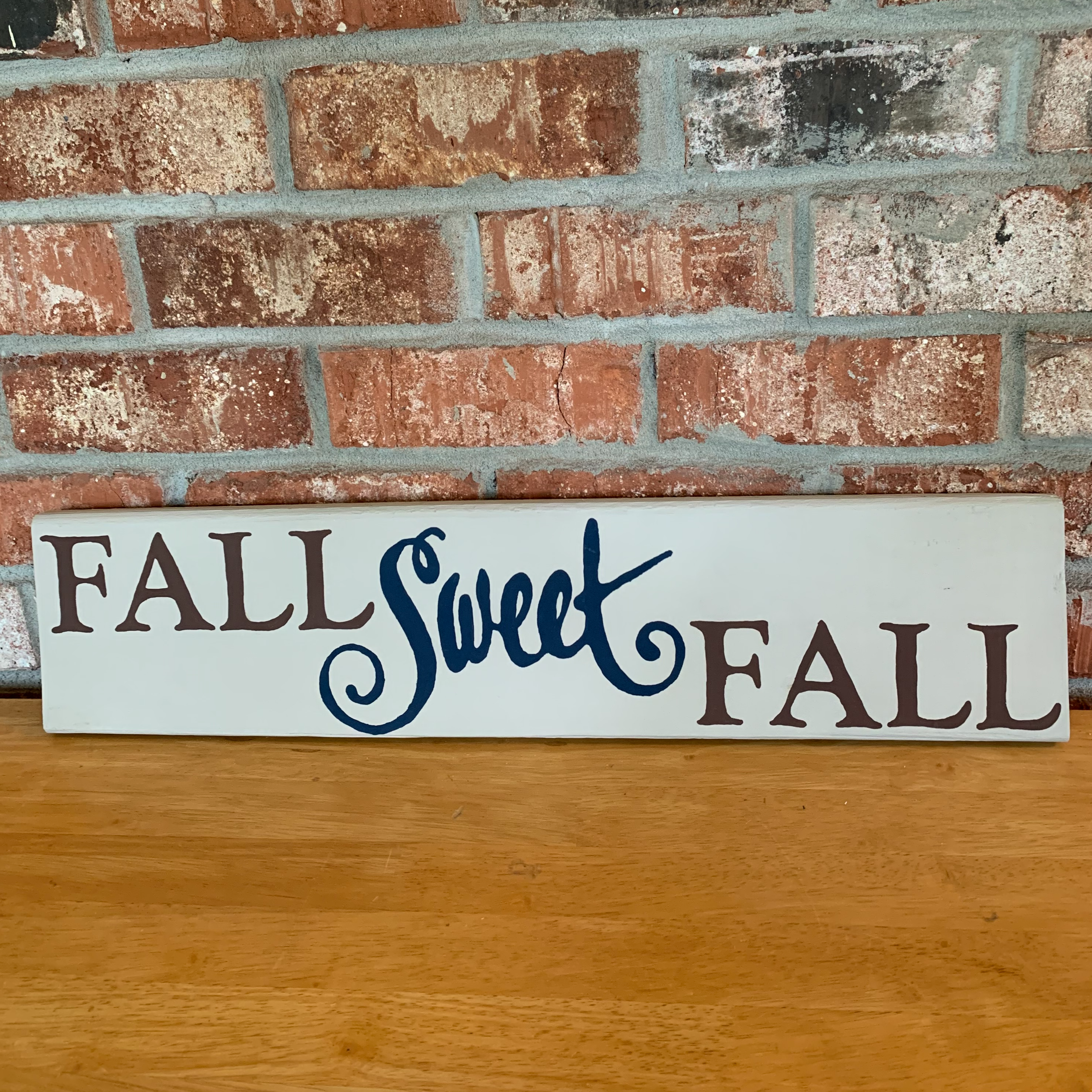 Hand painted cream, brown, and navy. Sign can be hung or even used as a leaner. Sign measures 24 1/8 x 5 1/4 inches.