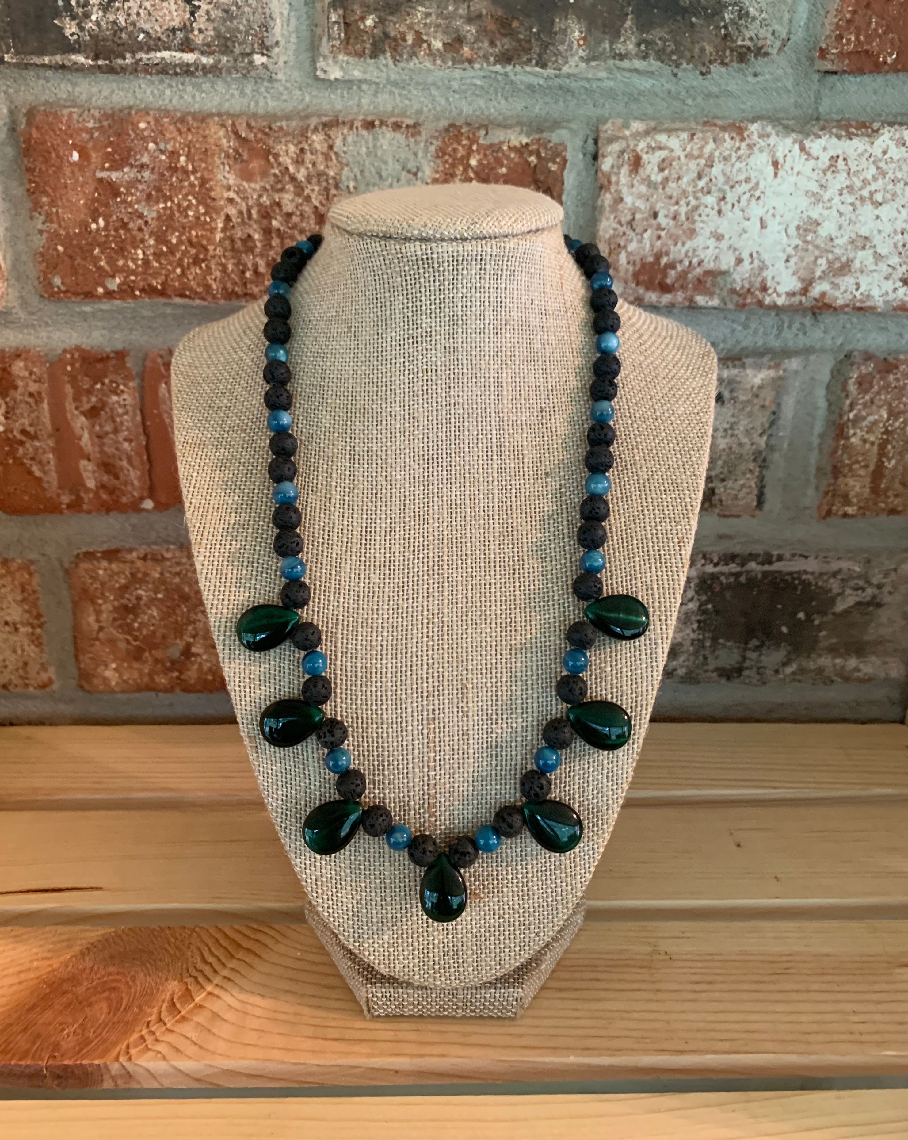 Made with lavestone, blue rivershell and green glass teardrop beads. Approximately 21 inches long.  Gun metal lobster clasp.