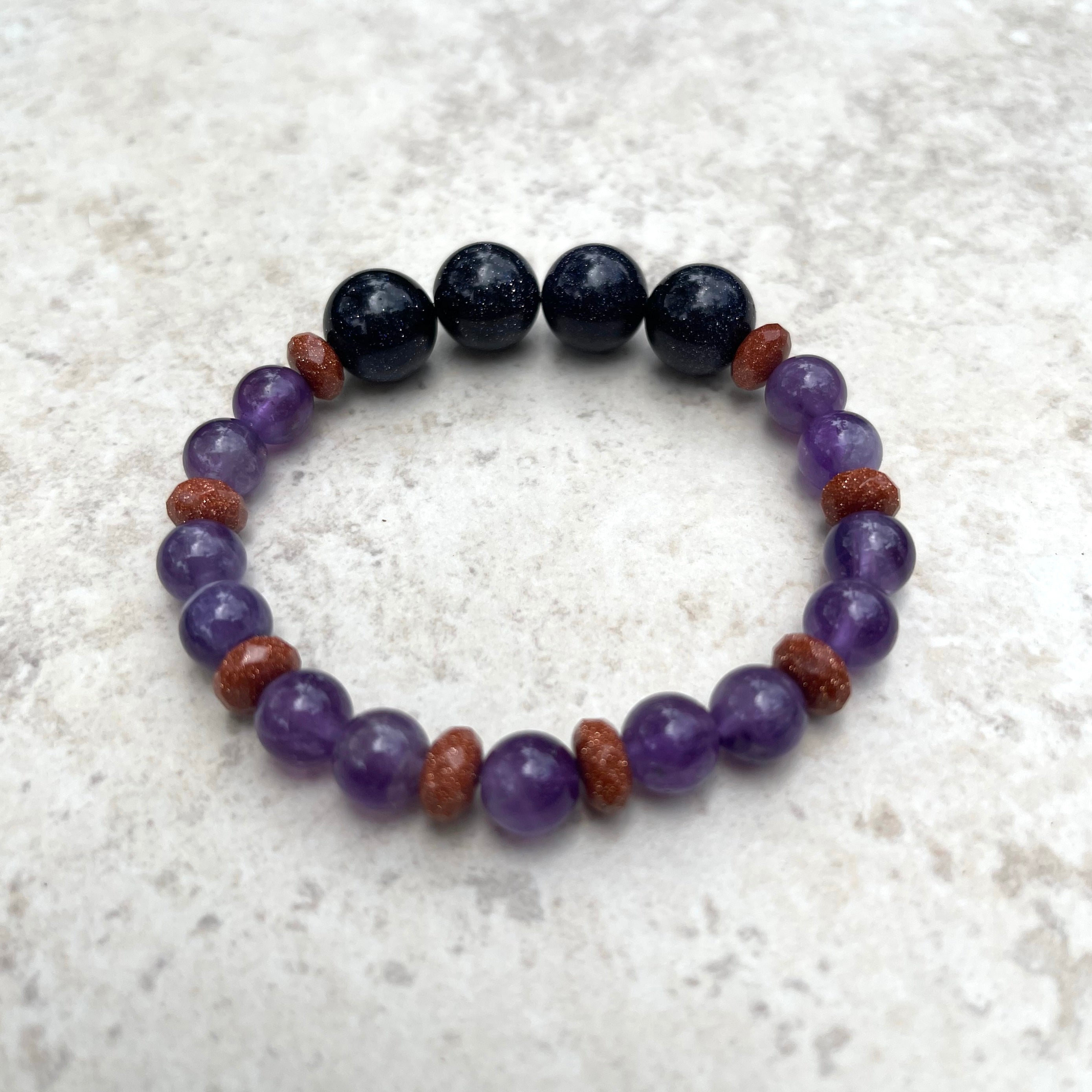 Handcrafted stretch bracelet on Profession Stretch Ninja Cord. Amethyst gemstone round beads. Goldstone and purple goldstone beads.