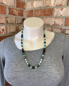 Opera length necklace at 29 inches. Handcrafted with Mint Quartz, Black Special Onyx, Snowflake Jasper, Zebra Stone, and green czech glass seed beads as spacers