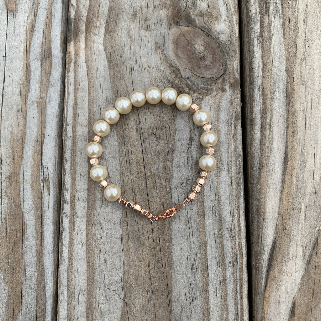 Bracelet is average length at 7 1/4 inches. Hand crafted with rose gold hematite and glass pearl beads. Copper lobster clasp with eye hook.