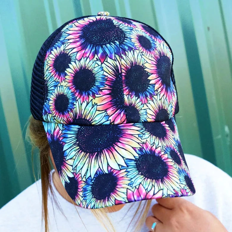 Sunflower prism ponytail cap. 65% Cotton, 35% Polyester. Print front. Black mesh back. Slot with criss-crossing elastic bands in back for high ponytail or bun. 7 panel - 2 solid, 4 mesh, and 1 with straps and closure. Adjustable velcro closure. Button top. Pre-curved visor. Adjustable, One Size Fits Most.